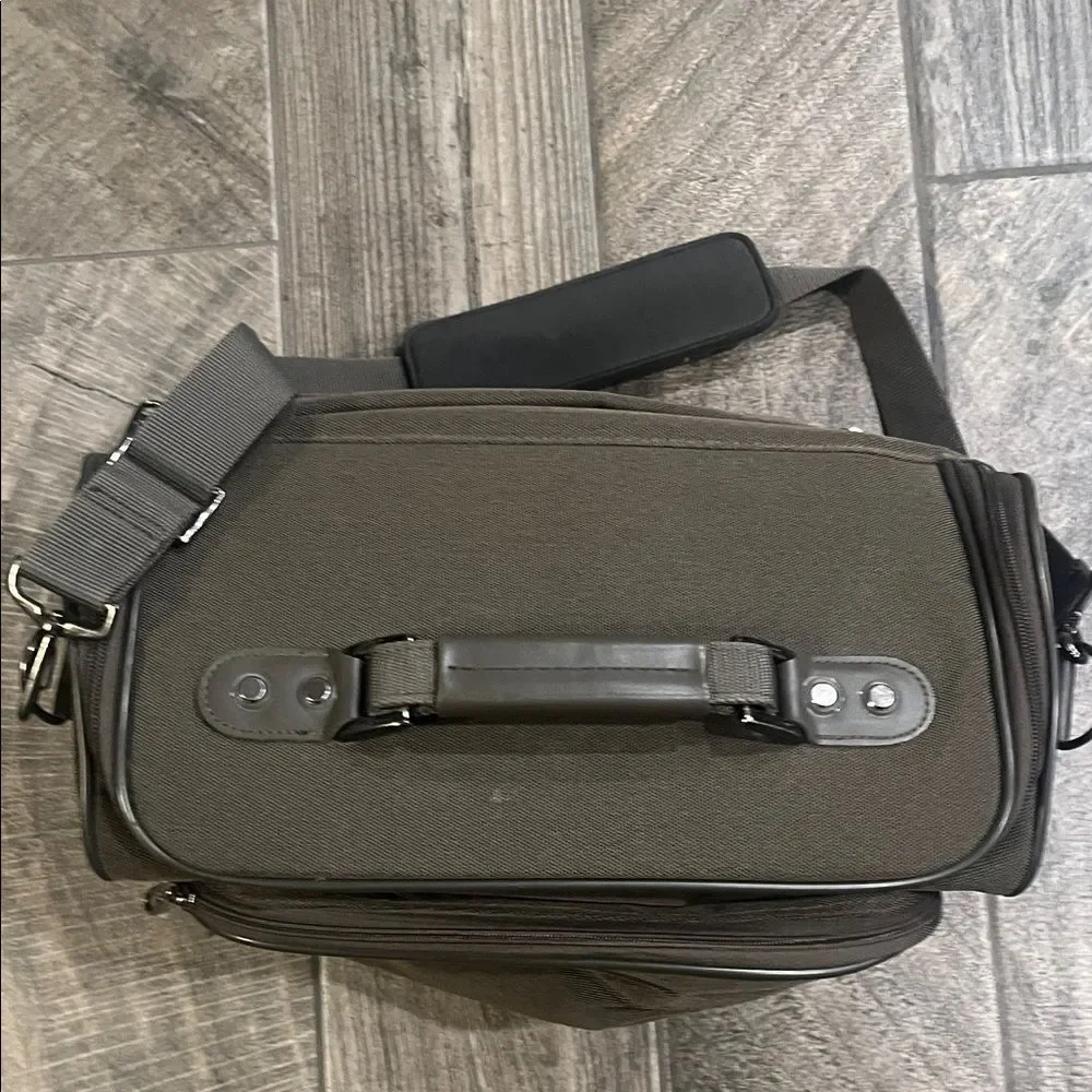 Samsonite army green Bag fits on luggage. 15”x 12”x 19” adjustable strap